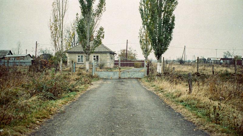 Paved access lane leading to the gate of a country cottage